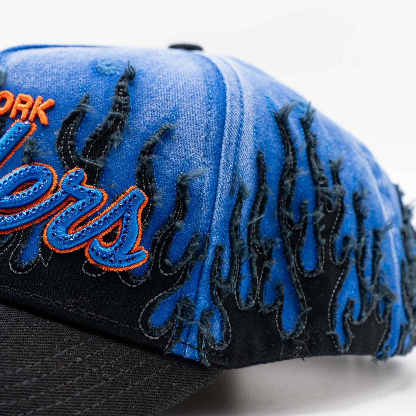 Blue and black cap with bold orange embroidered lettering and distressed flame pattern