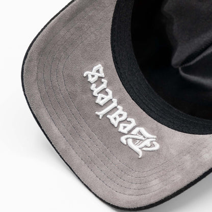 Close-up of suede grey hat brim with white embroidered script, urban streetwear style