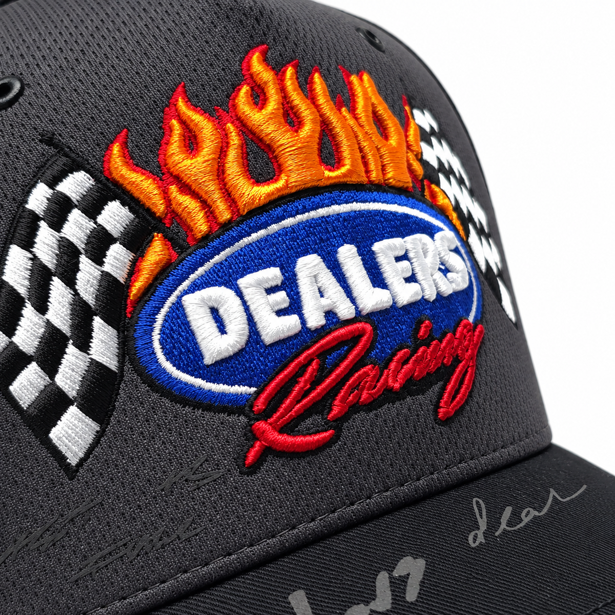 Close-up of the embroidered DEALERS Racing badge — flames, blue oval and checkered flags