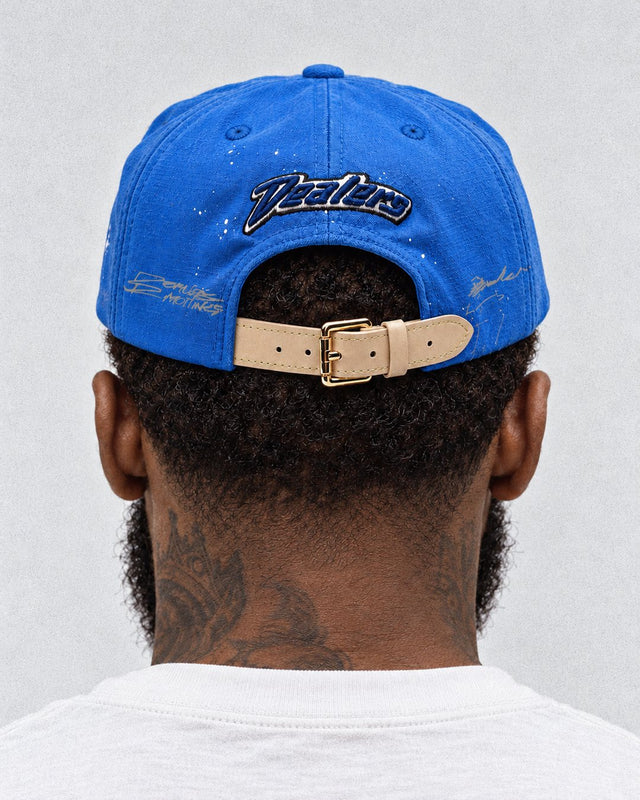 Back of the Dealers Unstructured Racing: navy Dealers script over the tan leather strap and gold buckle
